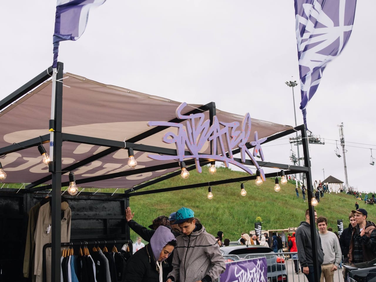 Booth canopy with the Anteater Clothing sign and festival flags