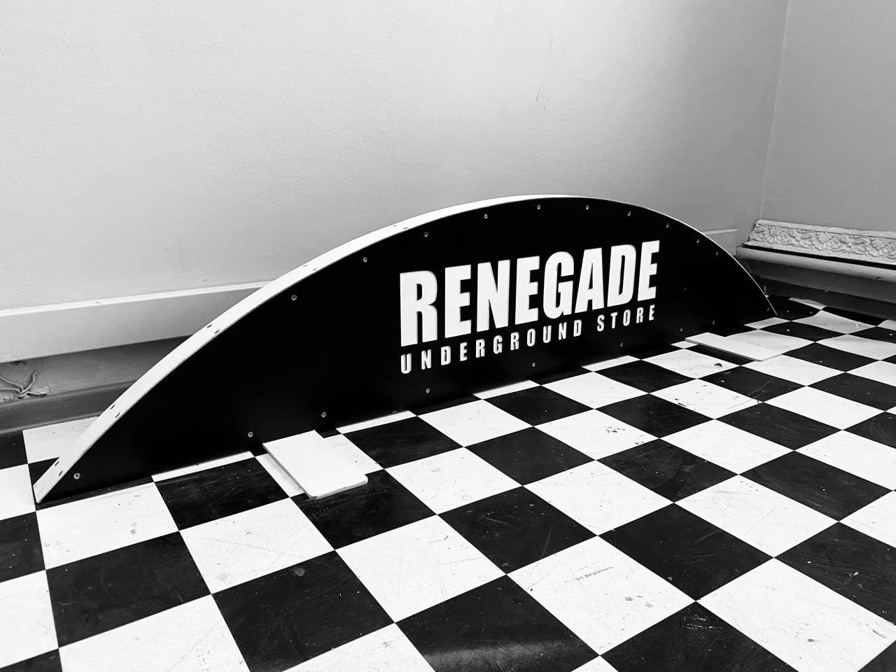 Hump ramp with Renegade Underground Store branding on a checkered floor
