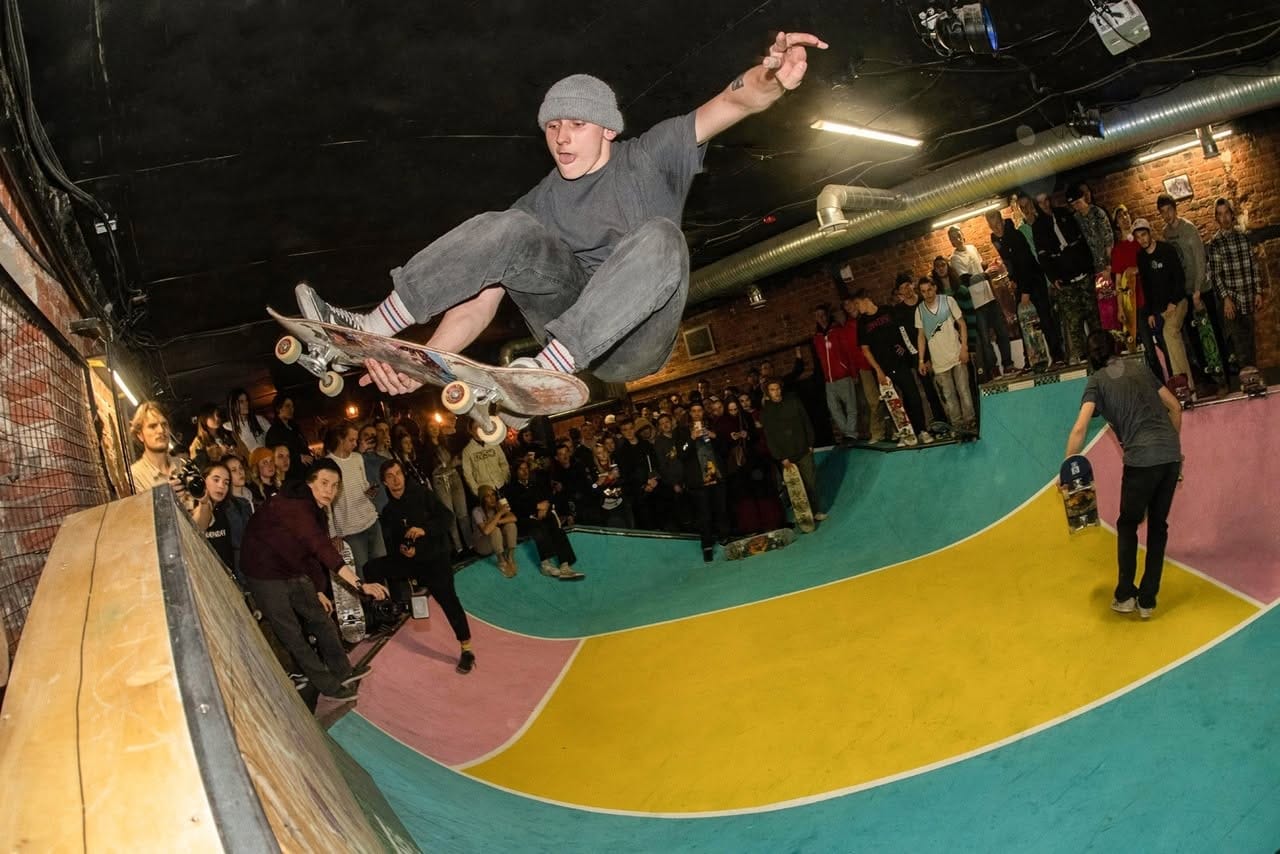 Skater airing over the vert extension of the Punk Fiction bowl in front of a crowd