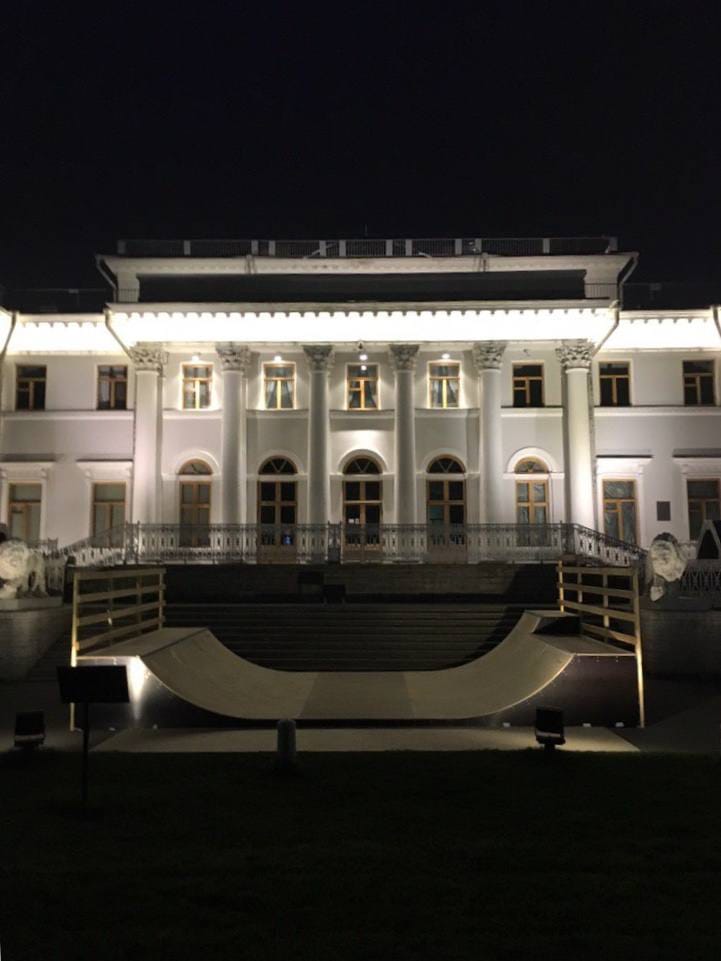 Mini ramp lit at night in front of a white colonnaded building