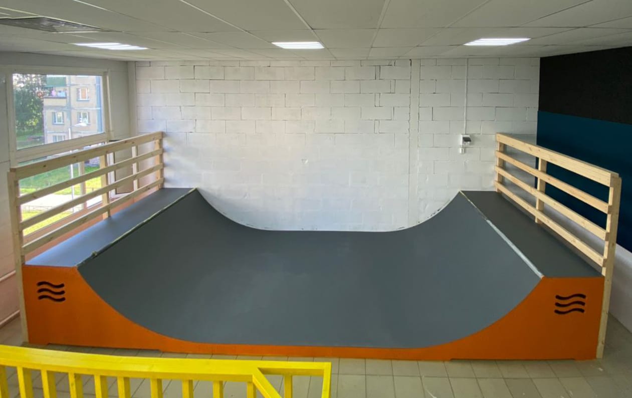 Indoor mini ramp with an orange frame and deck railings at the Nogam Dorogu roller club