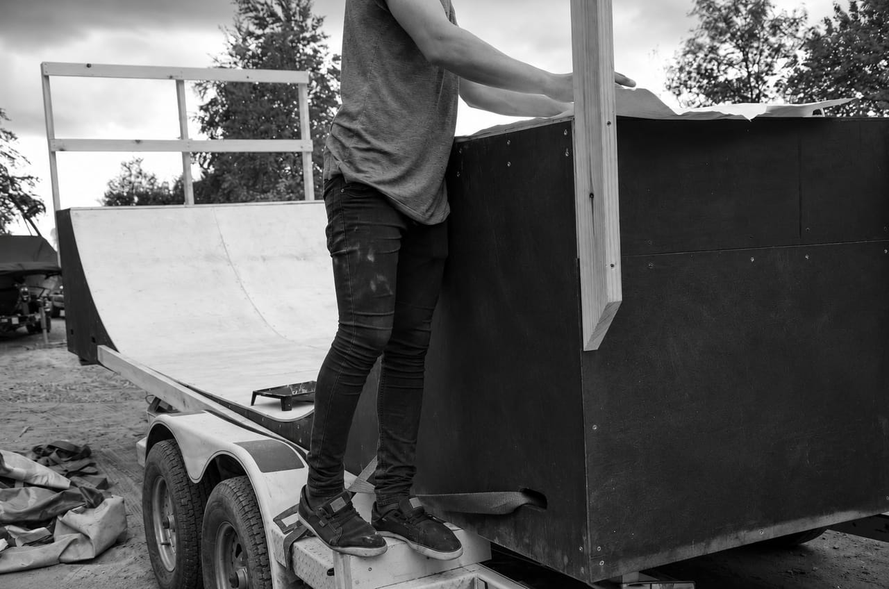 Black and white shot of a mini ramp being assembled on a trailer