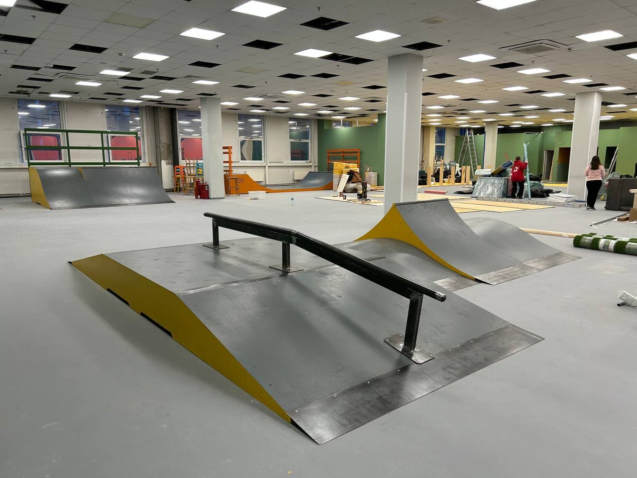 Funbox with a flat rail in an indoor street zone, with more obstacles in the hall behind