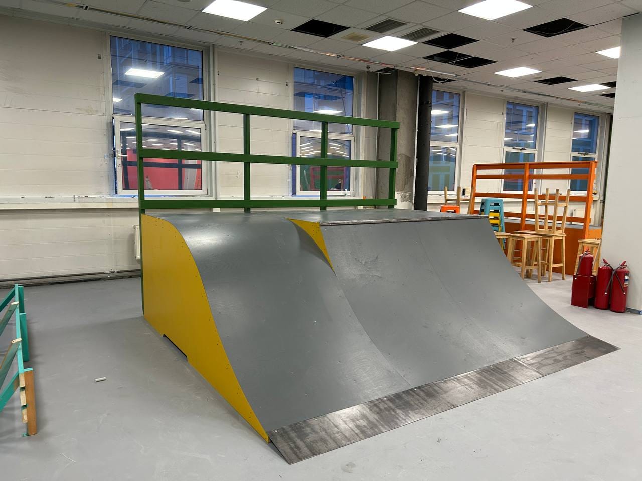 Bank with a green deck railing next to the hall windows