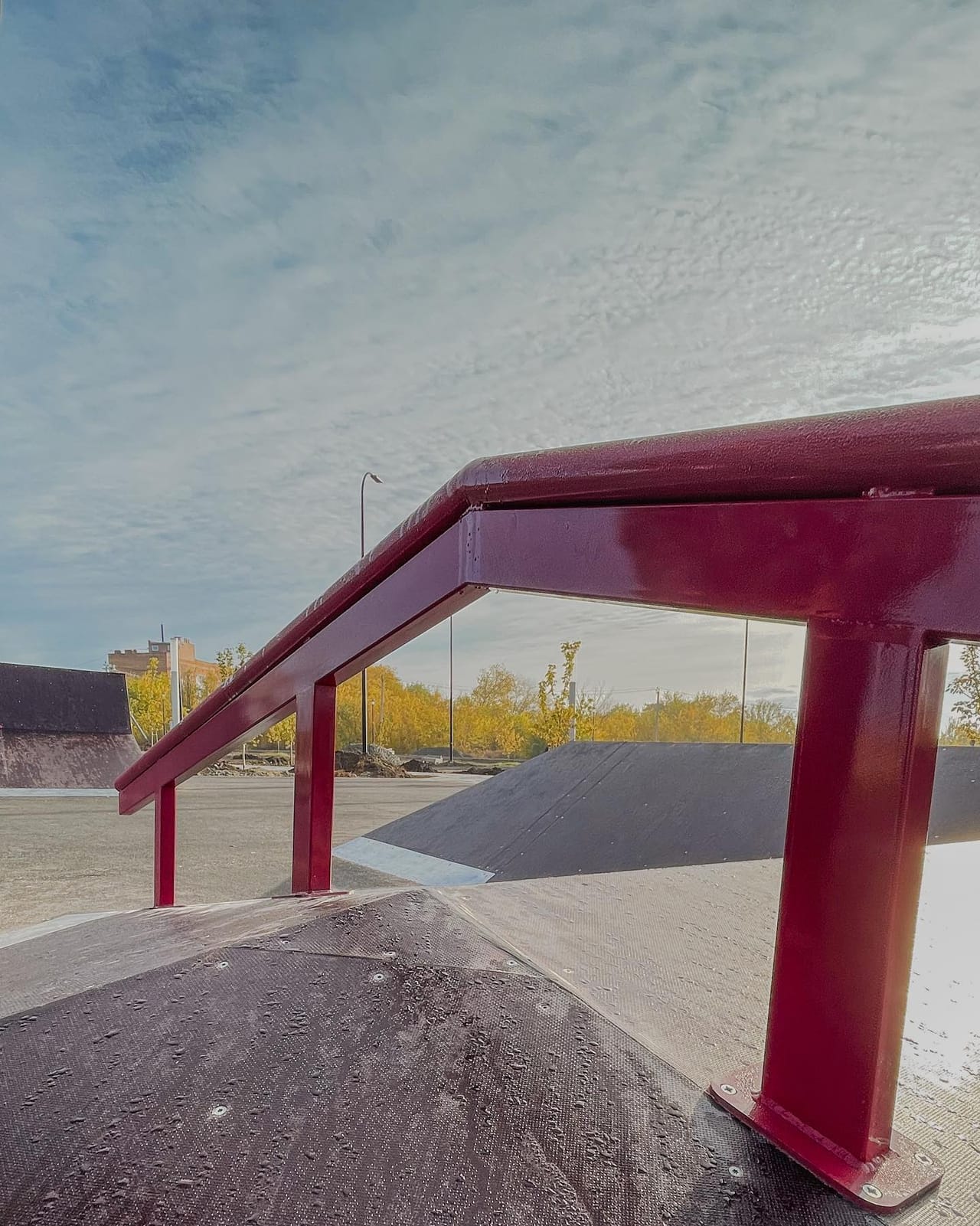 Red steel rail over a wooden hip at the Ust-Donetsky skatepark