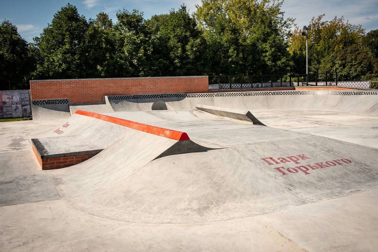 Street section of the Vans Skatepark with a concrete bank, orange steel-edged ledge and “Парк Горького” lettering