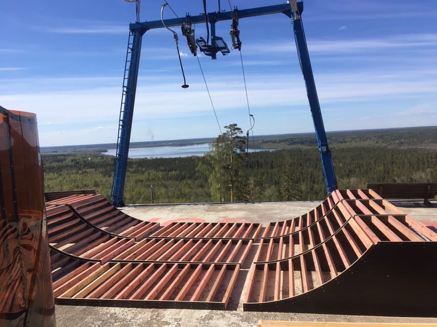 Ramp frames being built on a hilltop next to a ski lift