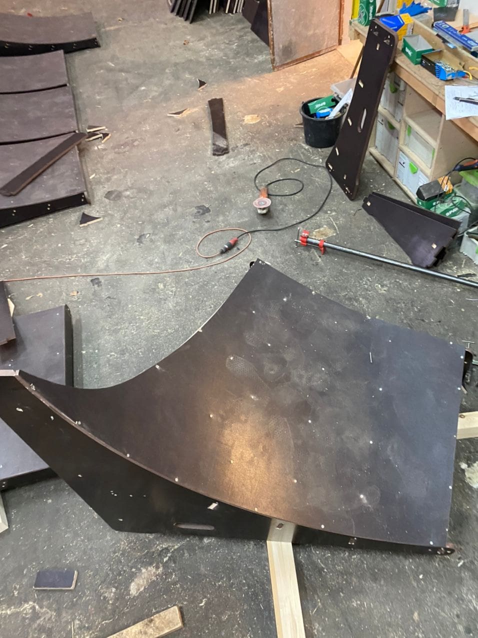 Curved plywood transition panel on the workshop floor
