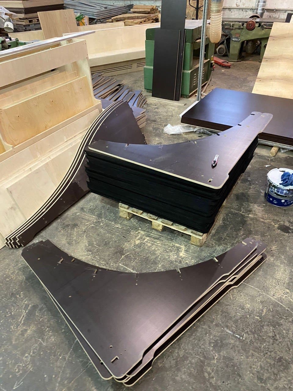 Cut plywood side panels stacked in the workshop